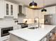 A well-equipped kitchen with white cabinetry, stainless appliances, an island with seating, and pendant lights at 2518 Pinckney Ave, Charlotte, NC 28205
