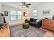 Living room featuring a tufted leather sofa, ottoman, and an area rug, all illuminated by natural light at 2518 Pinckney Ave, Charlotte, NC 28205