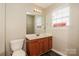 Bright bathroom featuring a wood vanity, mirror, and toilet at 2599 April Showers Ln, Rock Hill, SC 29730