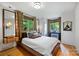 Comfortable bedroom featuring a king-size bed, hardwood floors, and ample natural light from surrounding windows at 2600 Cloister Dr, Charlotte, NC 28211