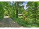 View of the driveway and lush landscaping of a mid-century home at 2600 Cloister Dr, Charlotte, NC 28211