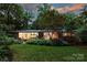 Lush landscaping frames the house exterior with picture window and brick facade at 2600 Cloister Dr, Charlotte, NC 28211