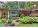 Mid-century modern home showcasing a brick facade, expansive windows, and lush, professionally landscaped greenery at 2600 Cloister Dr, Charlotte, NC 28211