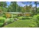 Well-maintained mid-century home features a brick facade, large windows, mature trees, and a manicured lawn at 2600 Cloister Dr, Charlotte, NC 28211