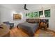 Cozy bedroom with hardwood floors, nature views, a stylish headboard and a ceiling fan at 2600 Cloister Dr, Charlotte, NC 28211