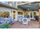 Spacious covered wooden back deck featuring patio seating, a grill, and views of nature at 29049 Snapper Pt, Tega Cay, SC 29708