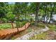 Backyard with lake view featuring a wooden staircase and stone pathway at 29049 Snapper Pt, Tega Cay, SC 29708