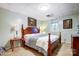 Well-lit bedroom featuring a wooden bed frame, travertine flooring, and neutral wall color at 29049 Snapper Pt, Tega Cay, SC 29708