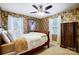 A charming bedroom with floral wallpaper, a ceiling fan, and ample natural light at 29049 Snapper Pt, Tega Cay, SC 29708