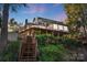 Charming multi-story home with wooden deck, stairs, and lush landscaping, creating a serene and inviting atmosphere at 29049 Snapper Pt, Tega Cay, SC 29708
