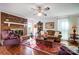 Warm living room features hardwood floors, a brick fireplace, and neutral-toned furniture at 29049 Snapper Pt, Tega Cay, SC 29708