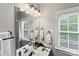 Bathroom with a double sink, large mirror with vanity lighting, and a window at 3007 Colonel Springs Way, Fort Mill, SC 29708