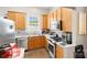 Well-lit kitchen featuring wood cabinets, stainless steel appliances, and tiled flooring at 3007 Colonel Springs Way, Fort Mill, SC 29708