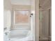 Relaxing bathroom featuring a soaking tub next to a window and a separate shower at 3014 Robin Terry Ct, Charlotte, NC 28208