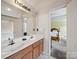 Bathroom featuring a double vanity with wood cabinets and a view into the adjacent bedroom at 3014 Robin Terry Ct, Charlotte, NC 28208