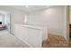 Bright hallway with neutral carpet and white railing leading to various rooms at 3014 Robin Terry Ct, Charlotte, NC 28208