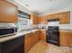 Functional kitchen featuring wood cabinets, black appliances, and laminate countertops at 3014 Robin Terry Ct, Charlotte, NC 28208
