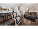 Inviting living room with a decorative tree mural and a comfortable leather sofa and chair at 3014 Robin Terry Ct, Charlotte, NC 28208