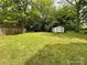 Spacious backyard with green grass, large trees, and an outdoor storage shed at 306 Sacco St, Belmont, NC 28012