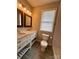 Bathroom with white cabinets, double sinks, grey tile floor, modern lighting, and a toilet at 306 Sacco St, Belmont, NC 28012