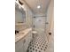Bathroom with white subway tile shower, black and white flower tile floor, and marble vanity at 306 Sacco St, Belmont, NC 28012