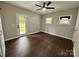 This bedroom features hardwood floors, a ceiling fan, and natural light from windows and a door at 306 Sacco St, Belmont, NC 28012