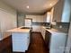 Modern kitchen with white cabinets, island, stainless steel appliances and grey backsplash at 306 Sacco St, Belmont, NC 28012
