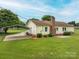 The photo exhibits the backyard, featuring a carport, yellow siding, and well-maintained landscaping around the home at 3537 Heather Ln, Gastonia, NC 28056