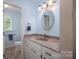 Bathroom features blue walls, a sink with granite countertops, and a mirror at 3537 Heather Ln, Gastonia, NC 28056