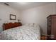 Cozy bedroom with floral bedding, wood dresser, and a small lamp at 3537 Heather Ln, Gastonia, NC 28056