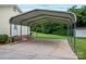 The photo shows the carport with a concrete pad and a view of the green backyard and adjacent storage building at 3537 Heather Ln, Gastonia, NC 28056