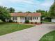 Quaint single-story house featuring manicured landscaping, a carport, and a welcoming facade at 3537 Heather Ln, Gastonia, NC 28056