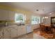 Bright eat-in kitchen featuring a stainless sink, white cabinets, and laminate countertops at 3537 Heather Ln, Gastonia, NC 28056