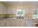 Bright kitchen featuring white cabinets, a sink, and a dishwasher, creating an efficient workspace at 3537 Heather Ln, Gastonia, NC 28056