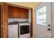 Laundry room with wooden cabinets and modern washer and dryer units at 3537 Heather Ln, Gastonia, NC 28056