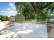 New concrete driveway leading up to a fenced backyard with mature trees and a green home at 406 N Bostian St, China Grove, NC 28023