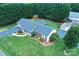 Overhead view of brick home with a well-kept lawn, mature trees, long driveway and wooden shed at 4646 River Run Cir, Hickory, NC 28602