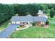 Stunning aerial view of a brick home with a lush green lawn, long driveway, and mature trees at 4646 River Run Cir, Hickory, NC 28602