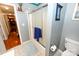 Bright bathroom featuring a shower with sliding glass doors, a toilet, and neutral tile flooring at 4646 River Run Cir, Hickory, NC 28602