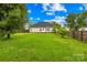 Expansive backyard with green lawn, wooden fence, and home exterior in the background at 4809 Mossy Cup Ln, Monroe, NC 28110