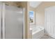 Bright bathroom featuring a glass shower, soaking tub, and neutral finishes at 4809 Mossy Cup Ln, Monroe, NC 28110