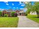 Inviting brick home with a long driveway and lush green lawn, perfect for Gathering living at 4809 Mossy Cup Ln, Monroe, NC 28110