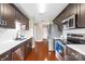 Modern kitchen with stainless steel appliances, white countertops, and dark wood cabinets at 4809 Mossy Cup Ln, Monroe, NC 28110