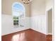 Bright room with a large arch window, hardwood floors, and modern white paneling at 4809 Mossy Cup Ln, Monroe, NC 28110