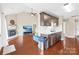 Open living room featuring a fireplace, TV, eat-in kitchen, hardwood floors, and lots of natural light at 4809 Mossy Cup Ln, Monroe, NC 28110