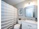 Bright bathroom featuring a large mirror, white vanity and toilet with neutral paint at 4925 Cedar Forest Dr, Charlotte, NC 28226
