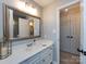 Bathroom with a white vanity, chrome fixtures, framed mirror, and doorway to closets at 4925 Cedar Forest Dr, Charlotte, NC 28226