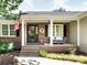 Charming front porch with brick steps, American flag, and cozy seating, perfect for relaxing outdoors at 4925 Cedar Forest Dr, Charlotte, NC 28226