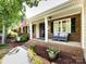 Welcoming front porch featuring brick accents, comfortable seating, and a classic American flag display at 4925 Cedar Forest Dr, Charlotte, NC 28226