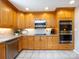 Functional kitchen equipped with stainless steel appliances, wooden cabinetry, and tile flooring for easy upkeep at 4925 Cedar Forest Dr, Charlotte, NC 28226